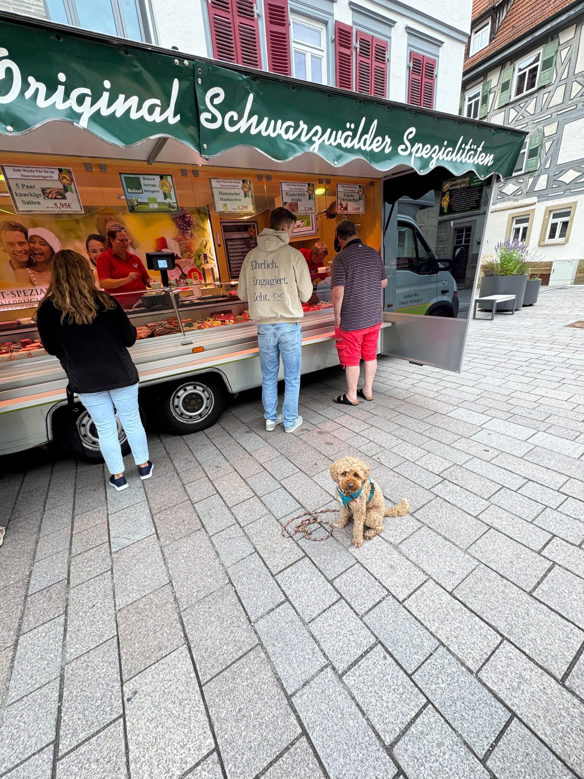 Der Verkaufswagen von Lothar Mei auf dem Wochenmarkt, davor wartet ein Pudel
